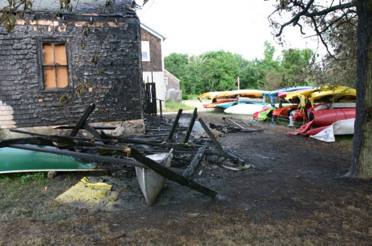 It apparently started in a porta-john at the rear of the building. It charred the entire back half of the building, burned an entire rack full of rental kayaks and canoes, and melted many more kayaks on nearby racks. Photo by Jon Alden